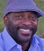 Headshot photo of book author DB with lavender shirt and hat for review of Mark Malatesta with interview